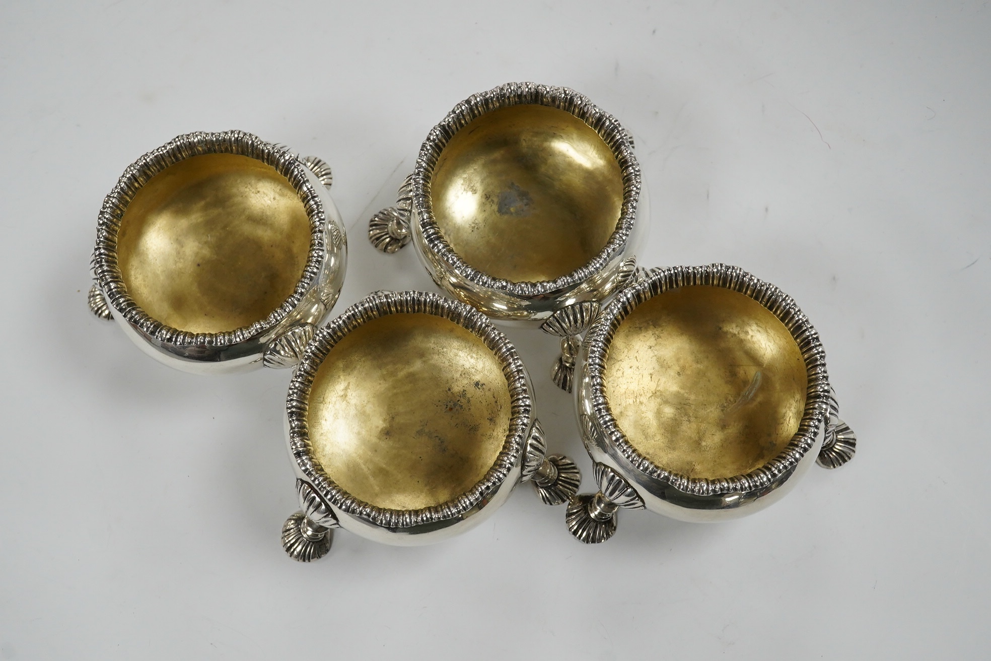 A set of four late William IV silver bun salts, on hoof feet, London, 1836, makers mark rubbed, diameter 72mm, 15.4oz. Condition - fair